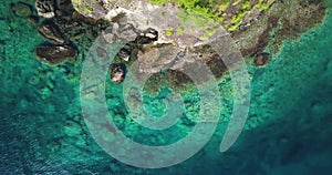 Aerial Drone view of a Tropical paradise coastline over a Caribbean island with Turquoise water and small waves hitting the rocks