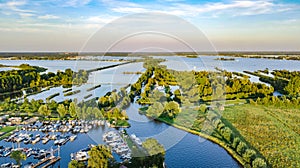 Aerial drone view of typical Dutch landscape with canals, polder water, green fields and farm houses from above, Netherlands