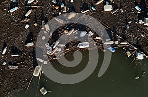 Aerial drone view waterfront scrap-heap plastic bottles rubbish pollution marine debris outdoors