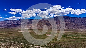 Aerial, drone view of white clouds over snow capped Eastern Sierra Nevada Mountains