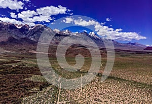 Aerial, drone view of white clouds over snow capped Eastern Sierra Nevada Mountains