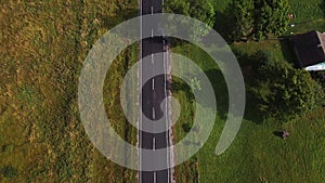 Aerial drone view of wide open empty road deep amongst wilderness forest with rolling hills and mountains