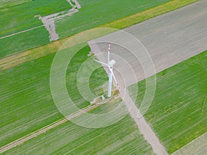 Aerial drone view of wind power turbines, part of a wind farm. Wind turbines on green field in countryside. Wind power plant