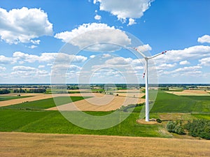 Aerial drone view of wind power turbines, part of a wind farm. Wind turbines on green field in countryside. Wind power plant