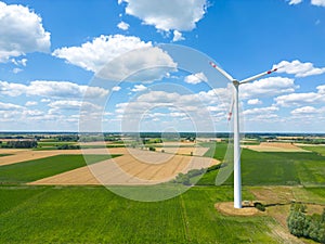 Aerial drone view of wind power turbines, part of a wind farm. Wind turbines on green field in countryside. Wind power plant