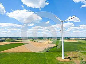 Aerial drone view of wind power turbines, part of a wind farm. Wind turbines on green field in countryside. Wind power plant