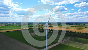 Aerial drone view of wind power turbines, part of a wind farm. Wind turbines on green field in countryside. Wind power plant