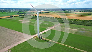 Aerial drone view of wind power turbines, part of a wind farm. Wind turbines on green field in countryside. Wind power plant