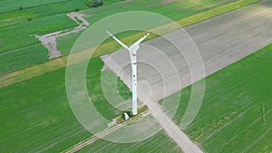 Aerial drone view of wind power turbines, part of a wind farm. Wind turbines on green field in countryside. Wind power plant