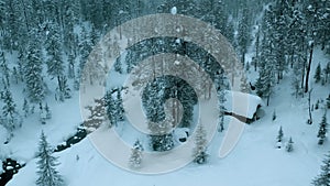 Aerial drone view on winter landscape with a river in a snowy mountain forest in a snowstorm. Winter Russia, Siberia