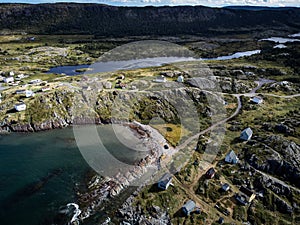 Aerial East coast community overlooking distant rugged terrain and lakes with shoreline homes at Keels Newfoundland Canada