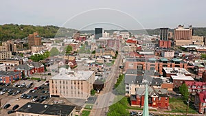 Aerial elevating up over a church clocktower and Charleston West Virginia