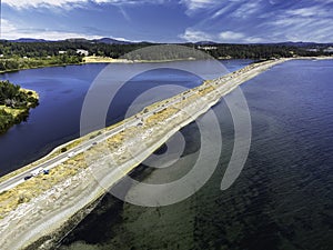 Aerial Esquimalt Lagoon sand spit overlooking Royal Roads University with a long straight road in Victoria British Columbia Canada