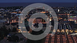 Aerial evening shot of urban borough and central train station with illuminated platforms. Helsinki, Finland