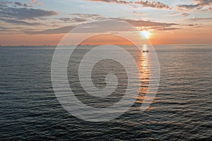 Aerial from a fishing boat on the North Sea and freighters at the horizon at sunset in the Netherlands