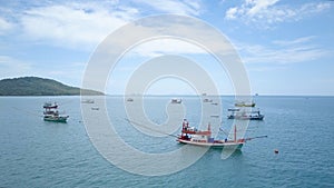 AERIAL: Fleet of fishing boats rest in calm waters of picturesque sea in summer.