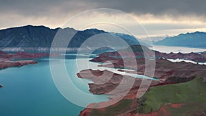 Aerial flight Beautiful spring landscape of river with blue turquoise water and hills against background of mountains