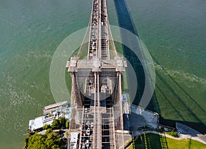 AERIAL flight over Brooklyn Bridge with American flag waving and East River view over Manhattan New York City Skyline
