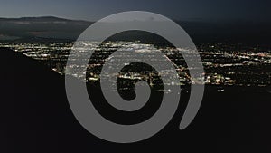 AERIAL: Flight over Hollywood Hills at Night with view on Valley , Burbank and City Lights