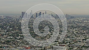 Aerial: flight over Los Angeles, California with Skyline in background, Cloudy in Daylight,