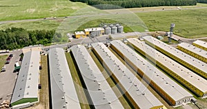 Aerial flight over silos and agro-industrial livestock complex on agro-processing and manufacturing plant with modern granary elev