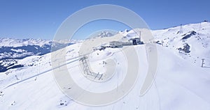 AERIAL: Flight over Ski Resort in Swiss Alps Mountains LAAX full with white snow on beautiful sunndy day