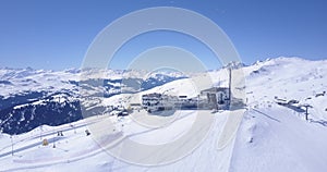 AERIAL: Flight over Ski Resort in Swiss Alps Mountains LAAX full with white snow on beautiful sunndy day