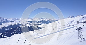 AERIAL: Flight over Ski Resort in Swiss Alps Mountains LAAX full with white snow on beautiful sunndy day