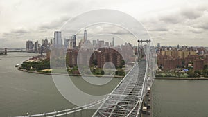 AERIAL: Flight over Williamsburg Bridge Manhattan side with New York City Skyline at cloudy day
