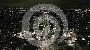 AERIAL: Flight over Wilshire Boulevard Street in Hollywood Los Angeles at Night with View on Streets and City Car