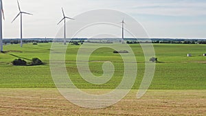 Aerial flight through windmills over green fields in Germany Mecklenburg Vorpommern