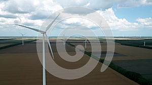 Aerial fly above wind turbines in an agricultural field