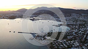 Aerial fly over Bodrum Halicarnassus bay with white houses at the sunset