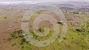 Aerial Flyby View on the Maasai village in on the coast of Natron Lake front of the Ol Doinyo Lengai, Mountain of God in