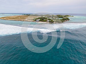 AERIAL: Flying above group of surfers paddling up to line up to ride big waves.