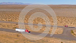 AERIAL: Flying above a red cargo truck enduring a long drive across Utah desert.