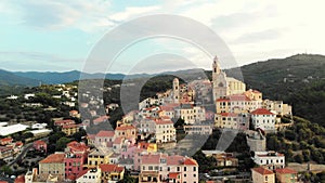 Aerial: flying around Cervo medieval town on the mediterranean coast, Liguria riviera, Italy, with the beautiful baroque church an