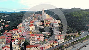 Aerial: flying around Cervo medieval town on the mediterranean coast, Liguria riviera, Italy, with the beautiful baroque church an