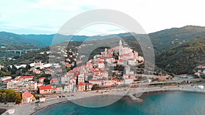 Aerial: flying around Cervo medieval town on the mediterranean coast, Liguria riviera, Italy, with the beautiful baroque church an