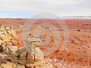 AERIAL: Flying around a woman standing atop a boulder overlooking canyon