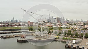 AERIAL: Flying inbetween industrial cranes in docks with New York City skyline in background and river