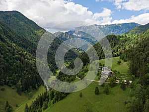 AERIAL: Flying over a small farm atop of a hill in scenic Logarska Valley.