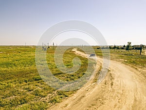 Aerial flying view of off road 4x4 truck vehicle moving on a dusty field d