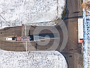 Aerial Follow Shot of White Semi Truck with Cargo Trailer Attached Moving Through Industrial Warehouse, Rural Area