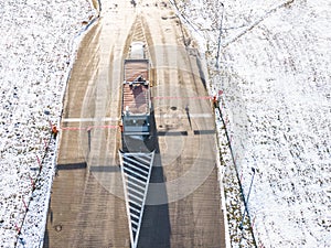 Aerial Follow Shot of White Semi Truck with Cargo Trailer Attached Moving Through Industrial Warehouse, Rural Area