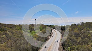 Aerial following video of a Highway on a sunny spring day. Light traffic.