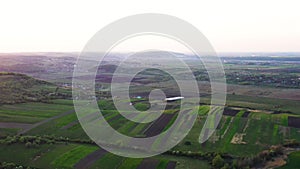 Aerial footage of an agricultural area and green rolling fields.