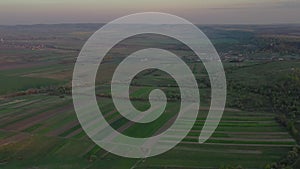 Aerial footage of an agricultural area and green rolling fields.