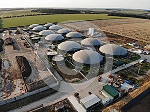 Aerial footage of biogas plant. Aerial view over biogas plant and farm in green fields