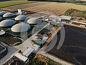 Aerial footage of biogas plant. Aerial view over biogas plant and farm in green fields